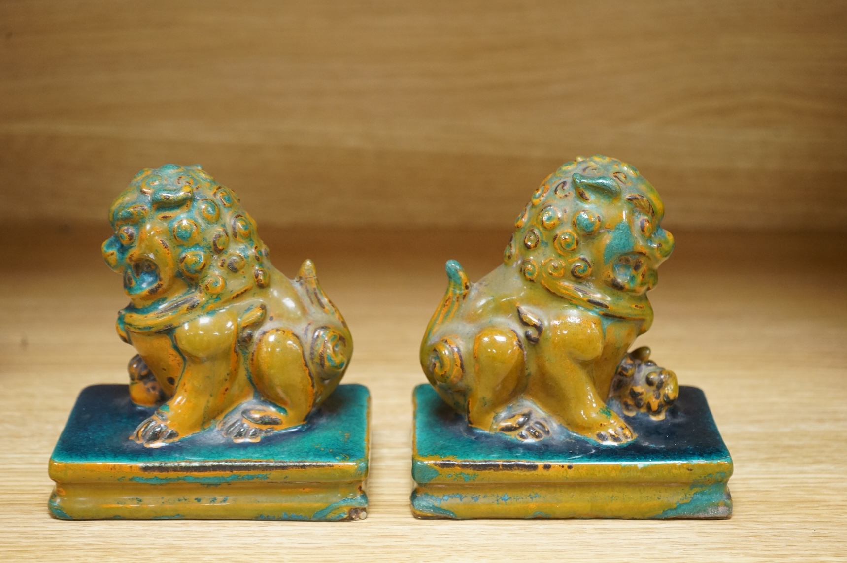 A pair of Chinese turquoise and olive green glazed ceramic lion dogs, Guandong kilns, 19th/20th century, impressed mark, 12cm